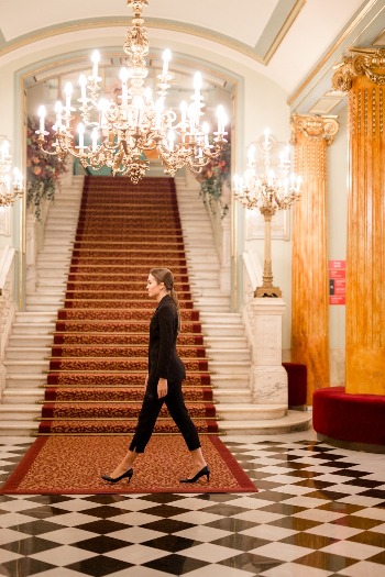 carnissa Mujer paseando por un vestíbulo donde se celebra el 25 aniversario de Carnisa, planificado por una agencia de organización de eventos.